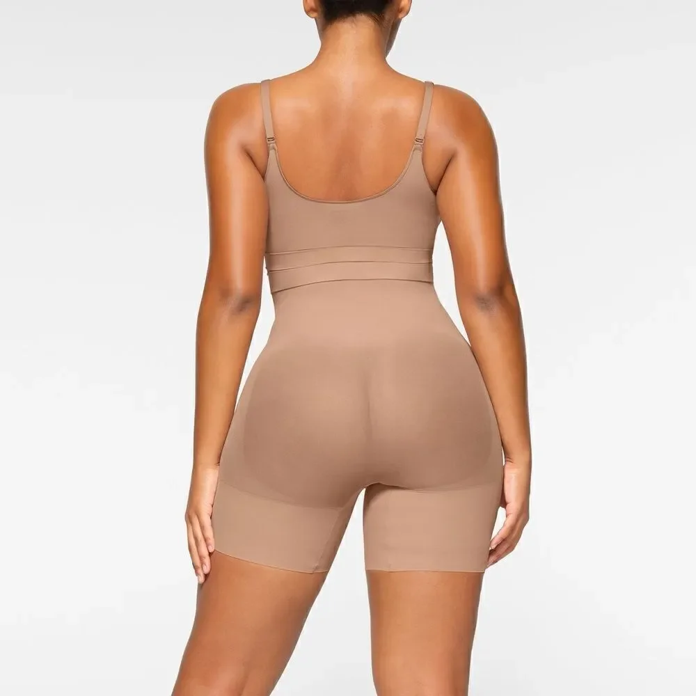 SKIMS high-waisted mid thigh short in color sienna in the size Small